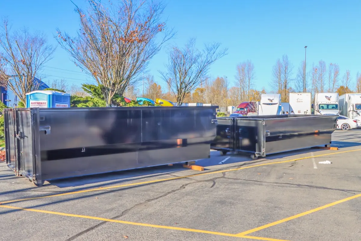 Professional dumpster rental service with roll-off container on residential driveway in West Warwick